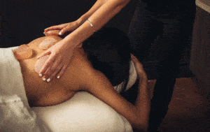 Massage Stones placed on the back of a guest during a massage at the Neptune Spa